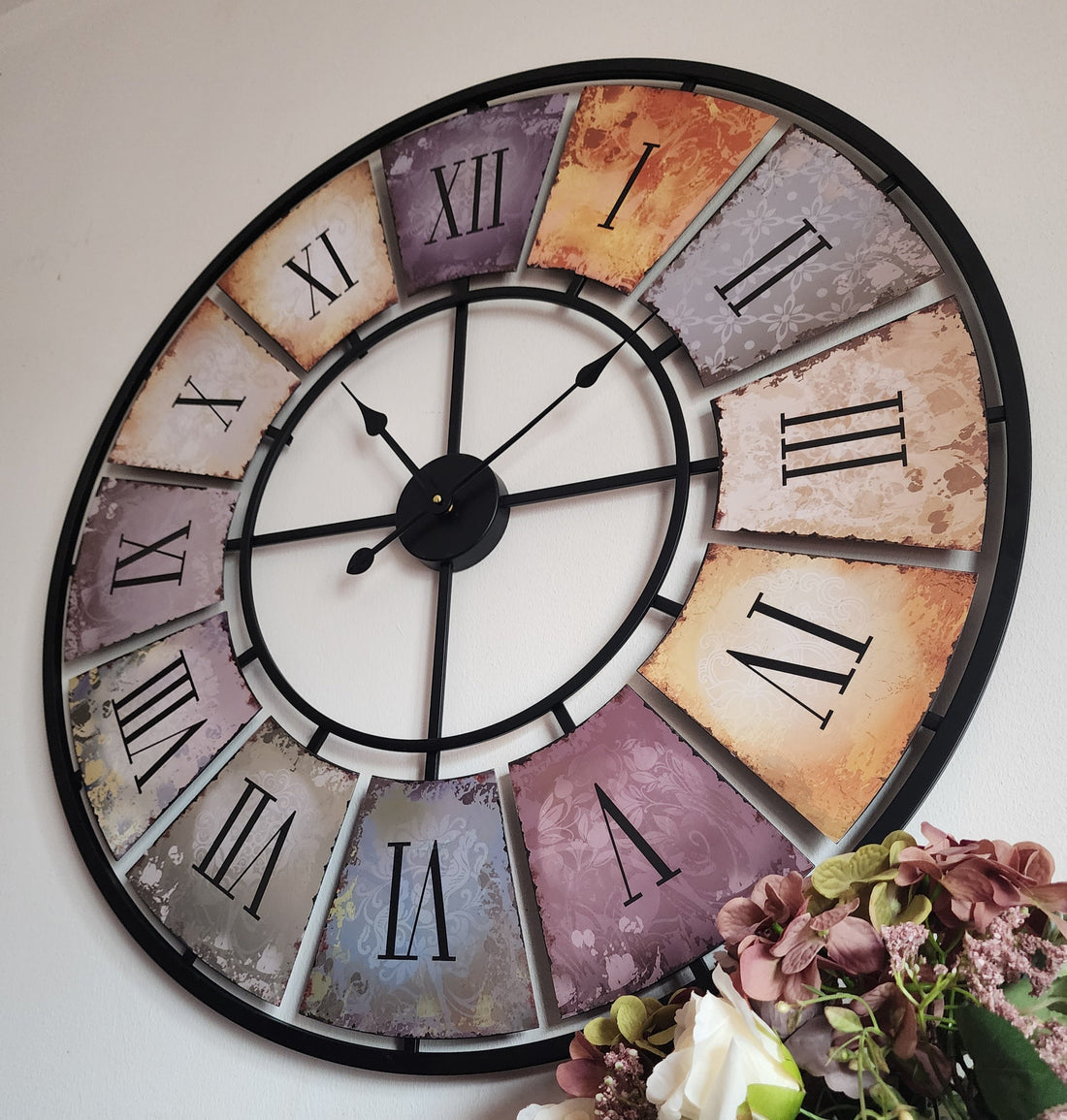 XXL 88cm Contemporary wall clock with vibrant colours and Roman numerals on a living room wall